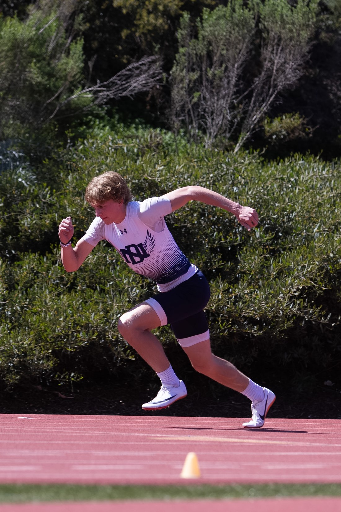 Cason Pollak sprinting in Del Norte Nighthawks uniform at a 2026 meet